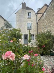 a brick house with flowers in front of it at Le Clos de l'Armançon - Maisons de charme au bord de la rivière - Classé 4 étoiles in Tonnerre