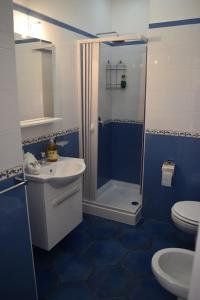 bagno blu con doccia e lavandino di La Casa di Cirro a Procida