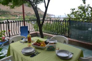 a table with a plate of fruit on a balcony at Aura Maris in Castellammare del Golfo
