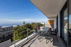 a balcony with a table and chairs on it at Plett Quarter Apartments in Plettenberg Bay