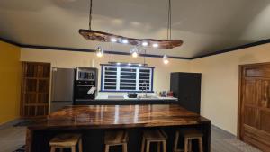 a kitchen with a large wooden island in the middle at Potter House VILLA PITA vue sur lagon et village de Fare in Teapaa