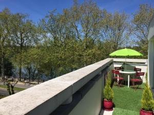 uma varanda com uma mesa e um guarda-chuva verde em Loire Terrasse em Tours