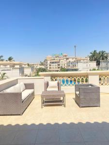 a patio with two chairs and a couch and a table at El Safwa Resort New Cairo in Cairo +105 photos