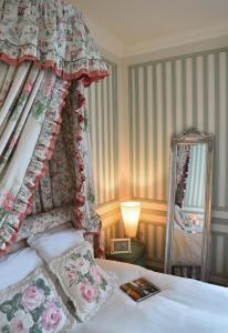 um quarto com uma cama de dossel e um espelho em La maison des 4 chats em Trouville-sur-Mer