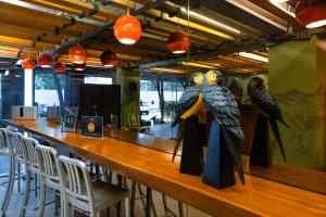 Eine Bar mit drei Papageien auf dem Tresen in der Unterkunft Metro Pratunam Boutique Hotel in Pratunam
