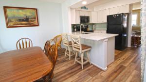 Una cocina y un comedor con una mesa y un refrigerador. en Capers #103, en Cape May