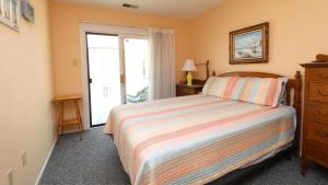 Un dormitorio con una cama y una cómoda y una ventana. en Capers #103, en Cape May
