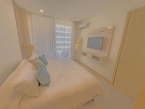a white bedroom with a bed and a television at Apart Suítes Stay Morros EOS - Acceso directo a la playa in Cartagena de Indias +42 photos