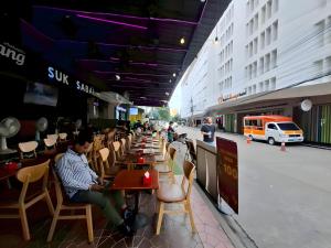 a group of people sitting at tables in a restaurant at The Hidden Khaosan - เดอะ ฮิดเด้นข้าวสาร รามบุตรี in Bang Bua Thong Railway Station