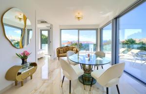 a dining room with a table and chairs and a mirror at Shimmer & Shine in Baška