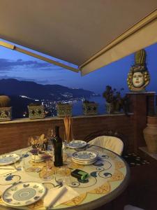 einen Tisch mit Tellern und eine Flasche Wein darauf. in der Unterkunft B&B Martina in Taormina