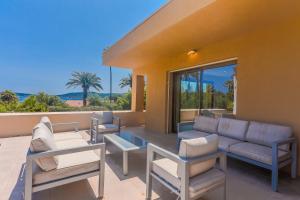 une terrasse avec un canapé, des chaises et une table dans l'établissement La Villa Capitane, à Grimaud