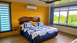 a bedroom with a bed with a bear head on the wall at Potter House VILLA PITA vue sur lagon et village de Fare in Teapaa
