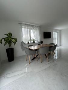 una sala da pranzo con tavolo, sedie e TV di Apartament Ilinca - 2 dormitoare a Bistriţa