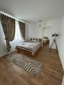 una camera da letto con un letto con un tappeto e un treppiede di Apartament Ilinca - 2 dormitoare a Bistriţa