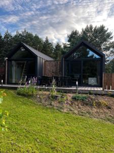 una casa nera con un ponte in un cortile di Domek Fantazja a Borków