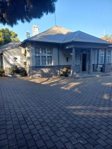 a house with a brick driveway in front of it at Triple9 Hatfield Guesthouse in Pretoria