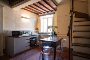 a kitchen with a table and chairs in a kitchen at Angolo sui tetti a Pietrasanta in Pietrasanta