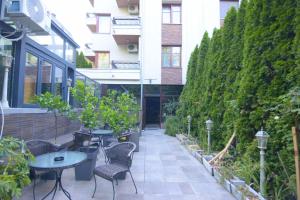 an outdoor patio with tables and chairs and plants at Cvetni konaci-Lenka in Vrnjačka Banja