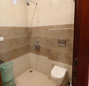 a bathroom with a toilet and a shower at Claremont Homestay By StayApart in Kasauli