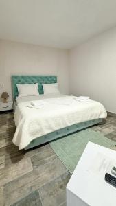 a bedroom with a large bed with a blue headboard at Complex Minerva in Costinesti