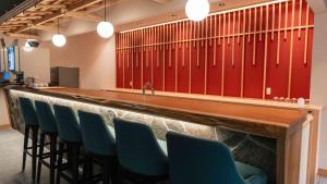 a bar with blue chairs in a room with red walls at Motosu Phoenix Hotel in Fujikawaguchiko