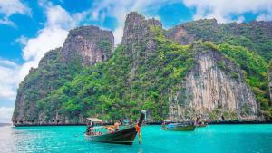 zwei Boote im Wasser vor einem Berg in der Unterkunft Base Ao Nang Beachfront Party Hostel 18-35 Years Old Only in Ao Nang Beach + 70 Fotos