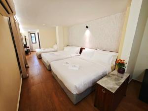 a hotel room with two beds and a table at Guan Gong Hotel Jin Shang Development Jonker Street in Malacca +4 photos