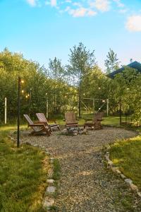 two wooden benches sitting on a gravel path in a park at Dobrede - будиночки під лісом in Dubrinich na Beregu +70 photos