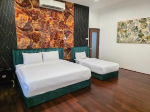 a hotel room with two beds and a painting on the wall at Bungalow Perkasa Kuala Lumpur in Kuala Lumpur +53 photos