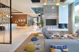 uma sala de estar com um sofá e uma TV em Adagio Premium The Palm no Dubai
