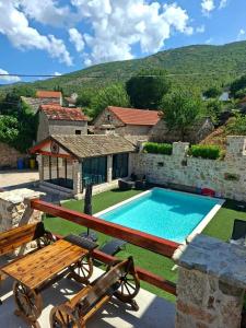 a house with a swimming pool next to a building at Villa Stone Valcer in Slivno