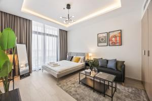 a living room with a couch and a table at Elite Escape - Getaway in Azizi Riviera 13 in Dubai