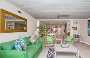 a living room with a green couch and a table at The Harbour #6 - 3 Bedrooms in Rodney Bay townhouse in Gros Islet