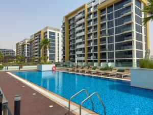 a large swimming pool in front of some buildings at Elite Escape - Getaway in Azizi Riviera 13 in Dubai