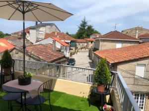 a balcony with a table and an umbrella at A Castelana de Cea in Cea