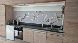 a kitchen with a sink and a counter with flowers on the wall at Ter Loft Courgette in Ternat