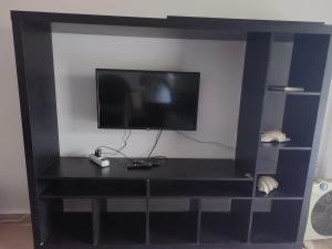 a black entertainment center with a flat screen tv at Mousa Cost Resort عائلات فقط in Ras Sedr