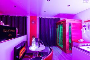 a room with pink and green lights and a table at "glamappartspa" design experience & Parking in Dijon