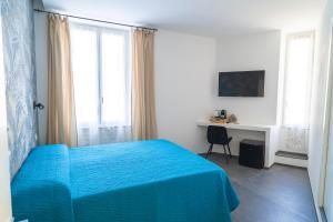 a bedroom with a blue bed and a desk at NoMad Guest House in La Spezia