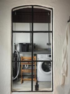 a view through a window into a kitchen with a washing machine at Ferienwohnung 4, Schlaf-Gut-Johannis, Flensburg in Flensburg