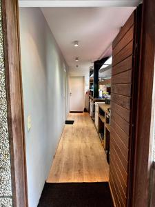a hallway leading to a kitchen with wooden floors at Ter Loft Courgette in Ternat