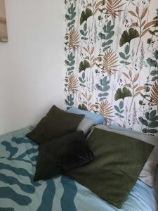 a bedroom with a bed with pillows and a curtain at Horizon Marin accès direct plage in Cabourg