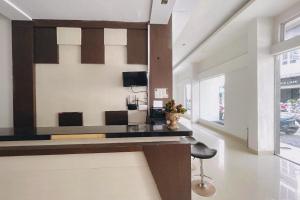 a living room with a table and a chair at RedDoorz at STM Suite Medan Amplas in Medan