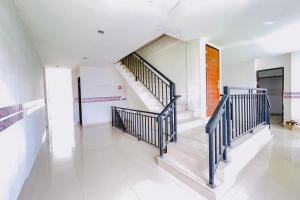 a hallway with stairs in a house at RedDoorz at STM Suite Medan Amplas in Medan