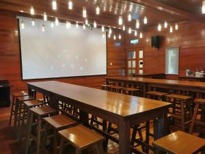 a classroom with tables and chairs and a projection screen at Borneo Happy Farm in Kuching
