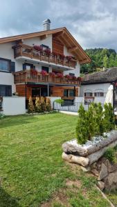 a large house with a balcony on top of a yard at La Sorgente Ville di Fiemme in Carano