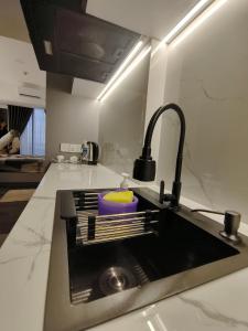 a kitchen with a sink with a faucet at Pollux Habibie Batam Polux in Batam Center