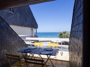 a blue table and chairs on a balcony with the ocean at Ty Fox by Madame est Servie in Perros-Guirec