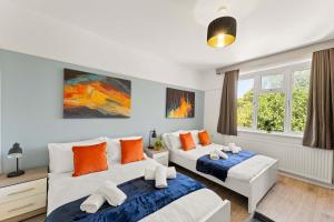 1 Schlafzimmer mit 2 Betten in Orange und Blau in der Unterkunft Stylish 5 Bed Home in Forest Hill by Amber Stays, Perfect for Business & Contractors Sleeps 16 in Forest Hill